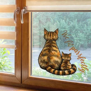 Detailed view of a cute tabby cat window sticker with 'We fit purrfectly' slogan on glass.