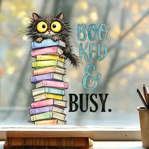 Decorative window sticker featuring a scruffy cartoon cat on colorful books with Booked & Busy text