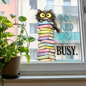 Detail view of a cute cartoon cat and books window sticker with 'Booked & Busy' text slogan.