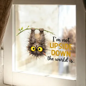Detail view of upside down cat window sticker with humorous English quote on glass.