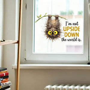Close-up view of a funny fluffy cat window sticker with 'I'm not upside down' quote