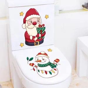 Close-up view of festive Santa and snowman stickers on a white toilet seat cover