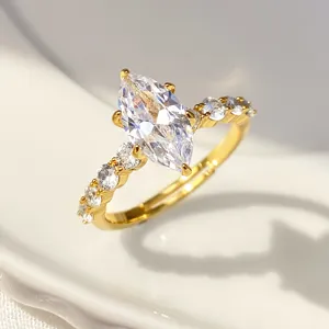 Close-up of gold marquise-cut zircon ring with sparkling side stones and fire