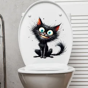 Detail eines lustigen schwarzen Katzenaufklebers auf einem weißen Toilettendeckel im Badezimmer