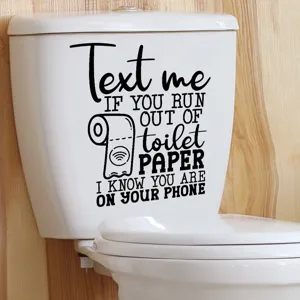 Close-up of a funny 'Text Me' toilet paper decal applied on a white ceramic toilet tank
