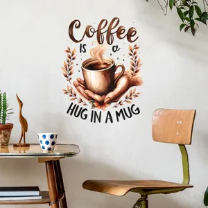 Αυτοκόλλητο τοίχου καφέ με το κείμενο 'Coffee Is A Hug In A Mug' σε λευκή επιφάνεια.