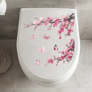 Top view of pink plum blossom and butterfly stickers applied on a white toilet lid