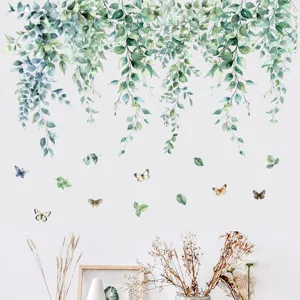 Detailed view of green hanging leaf wall decals with butterflies on a clean white wall.