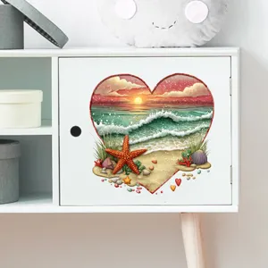 Detail of heart-shaped beach sunset wall sticker applied to a white cabinet door.
