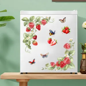 Verse aardbei- en vlindermuurstickers op een witte decoratieve kleine koelkast in de keuken