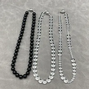 Detailed view of clear crystal and black beaded necklaces with magnetic clasps