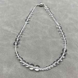 Macro view of transparent white crystal bead necklace with silver magnetic clasp.