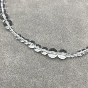 Macro detail view of clear crystal round beads on a minimalist magnetic necklace.
