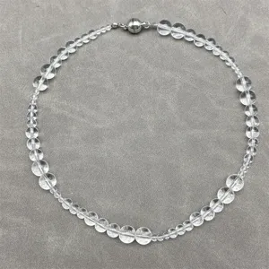 Close-up detail of a transparent white crystal beaded necklace with magnetic clasp.