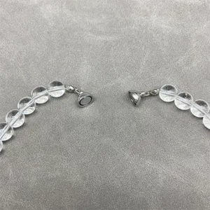 Close-up detail of a transparent crystal bead necklace featuring a secure magnetic clasp.