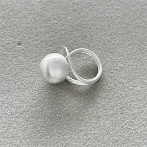 Primer plano de un anillo minimalista de plata mate cepillada con una esfera grande