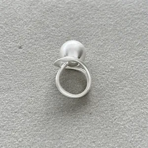 Vista detallada de un anillo minimalista de plata mate con una gran esfera cepillada