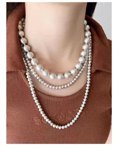 Primer plano de un collar de tres capas con elegantes esferas de plata cepillada.