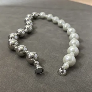 Detail view of the pearl and silver bead necklace with its secure magnetic clasp.