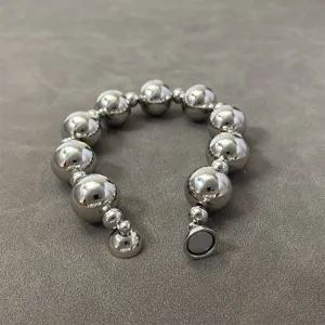 Detailed close-up of a silver metallic beaded necklace featuring a strong magnetic clasp
