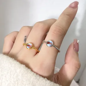 Close-up detail of minimalist moonstone rings in elegant gold and silver finishes