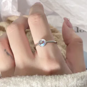 Macro view of a minimalist silver ring featuring a beautiful glowing moonstone.