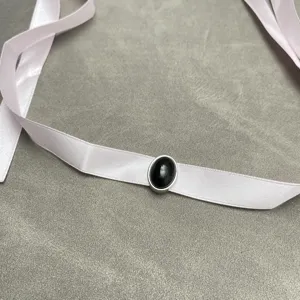 Detailed view of elegant pink ribbon choker with an oval black gemstone pendant.