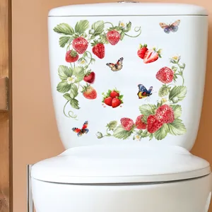 Detailweergave van waterdichte aardbei- en vlinderstickers op een wit keramisch toilet