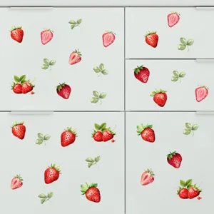 Levendige aardbei muurstickers aangebracht op het oppervlak van een schoon wit keukenkastje