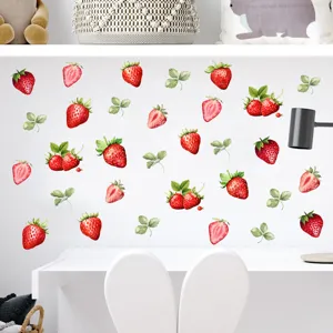 Aquarel aardbei muurstickers decoreren een witte kinderkamermuur boven een bureau