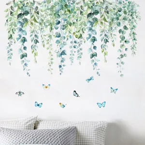 Fresh watercolor eucalyptus hanging leaves and blue butterflies wall decals in bedroom scene.