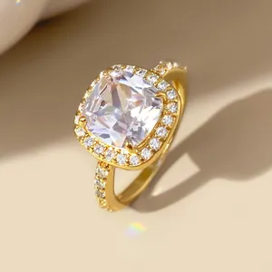 Detailopname van luxe gouden ring met vierkant geslepen zirkonia en halo pavézetting.