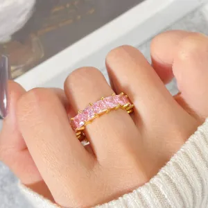 Detailaufnahme eines goldenen Hip-Hop-Rings mit quadratischen rosa Zirkoniasteinen