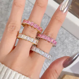 Detailansicht von gestapelten quadratischen rosa und weißen Zirkonringen im Hip-Hop-Stil