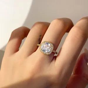 Dichtbij van een luxe zirkonia halo-ring met gouden band op een vrouwelijke vinger