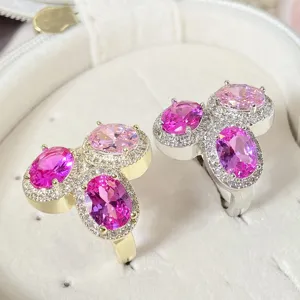 Nahaufnahme von silbernen und goldenen Ringen mit ovalen rosa Halo-Edelsteinen
