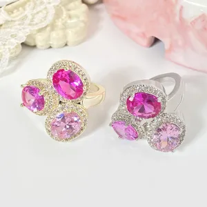 Detailansicht von zwei ovalen rosa Gradienten-Edelsteinringen in Gold und Silber