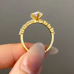 Detail of gold ring featuring a central round stone and marquise-cut zircons.