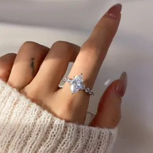 Elegant close-up view of a sparkling marquise-cut zircon ring with a claw setting on finger.