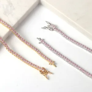 Close-up macro detail of pink zircon tennis chains with gold and silver finishes