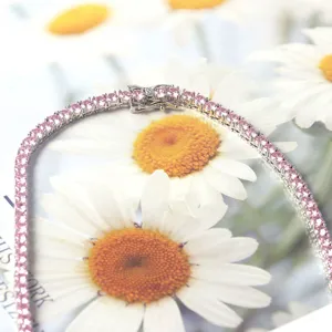 Close-up detail of an elegant tennis chain necklace featuring vibrant round pink stones