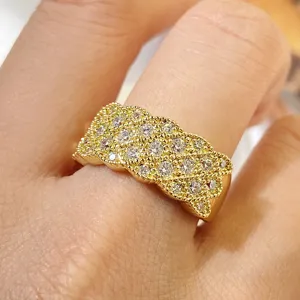 Luxuriöser vergoldeter breiter Ring mit Zirkonia-Pavé-Steinen an der Hand eines Models