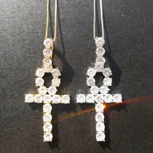 Primo piano di ciondoli Ankh in oro e argento con zirconi da 5 mm su catene sottili.