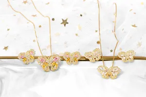 Detail eines goldenen Schmetterlingsschmuck-Sets mit rosa und gelben Zirkonia-Kristallen