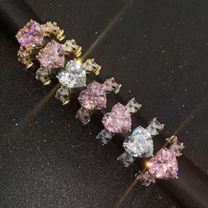 Nahaufnahme von funkelnden herzförmigen rosa und klaren CZ-Ringen mit Mikro-Pflaster.