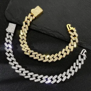 Detailed close-up of gold and silver pavé iced-out hip hop Cuban link bracelets on stone