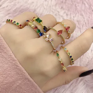 Detailaufnahme von stapelbaren vergoldeten Ringen mit bunten Zirkonia-Edelsteinen an der Hand.