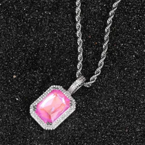 Close-up of a pink square zircon pendant necklace with a rope chain on a black textured background.
