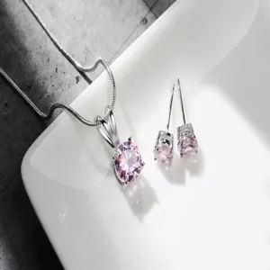 Primo piano dettagliato di elegante set collana e orecchini con pietra rosa metallo argento.