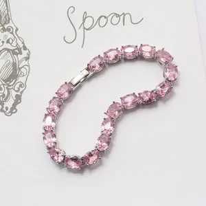 Nahaufnahme eines Armbands mit rosa Zirkonia-Steinen auf weißem Hintergrund.